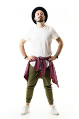 Confident cocky attitude hipster with hat in chino pants posing with hands on hips. Full body portrait isolated on white background