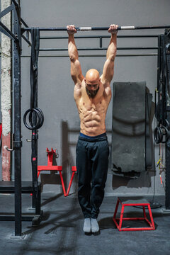Strong athlete hanging on chin up bar