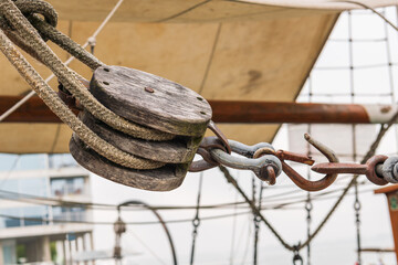 Obraz premium Details of wooden pulley part of a block and tackle on a tall ship moored in Toronto's Inner Harbour, shot on a summer morning.