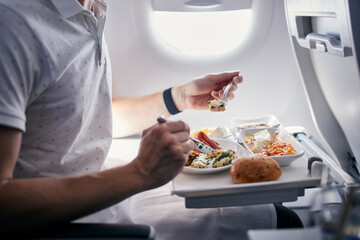 Passenger eating airline meal. Menu in business class on medium haul flight. - 442940372