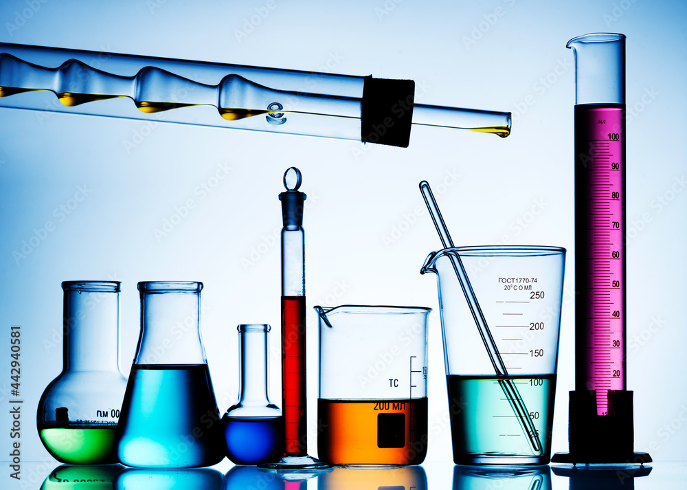 Wall mural different laboratory glassware with color liquid and with reflection