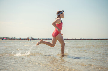 Fototapeta premium Happy little child girl running and having fun on beach at sunny summer day