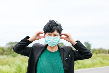 Fototapeta premium Close-up of a man in a suit working in a protective mask outdoors Man wearing mask close-up in city background. New normal. Concept of health care during coronavirus or covid pandemic.