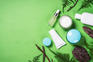 Natural Cosmetic products. Cream, serum bottle and green plants with bark. Biophilic concept. Flat lay image with copy space.