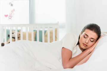 young Brunette woman sleeping on white bedding
