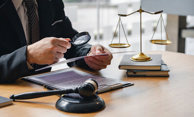 Attorney or judge sitting at  desk, holding magnifying glass and reading book. Businessman, business auditor, teacher, professor searching for information, fact-checking, law consulting professional