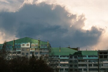 A dark blue thundercloud over modern house construction