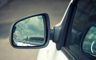 Obraz premium Broken car wing mirror. Damaged car side mirror, cracked glass. Bad driving, problems with car. Road accident concept