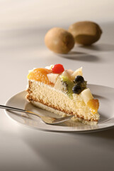 Kuchen, Obstkuchen, Fruchttorte, Stück auf Teller, Kiwi, Traube, Mandarine, Birne