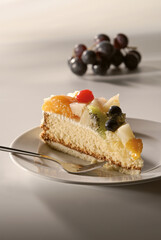 Kuchen, Obstkuchen, Fruchttorte, Stück auf Teller, Kiwi, Traube, Mandarine, Birne