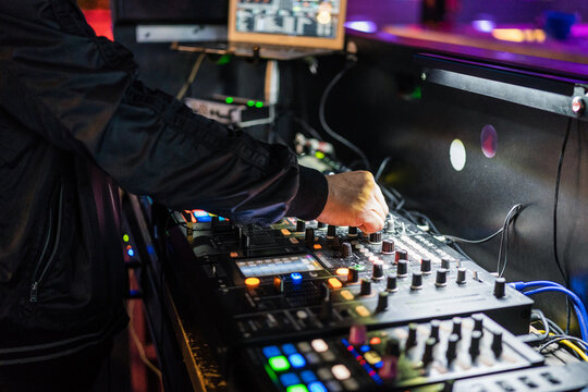 DJ using controller while performing on stage in nightclub