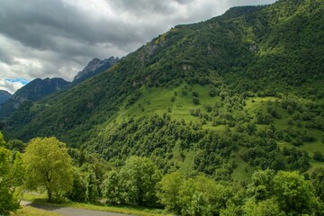 Paisaje natural de Cette-Eygun, un pequeño pueblo en el lado norte de los Pirineos franceses. Hermosas laderas verdes al final de la primavera en un día nublado. Francia.