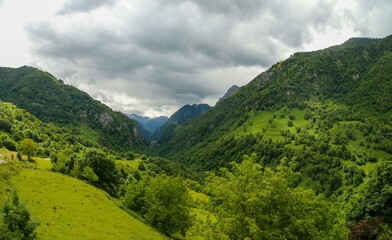 Paisaje natural de Cette-Eygun, un pequeño pueblo en el lado norte de los Pirineos franceses. Hermosas laderas verdes al final de la primavera en un día nublado. Francia.