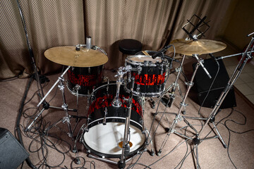 The drum kit is on the stage at the rehearsal base.