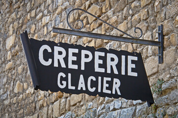 panneau avec écrit dessus crêperie et glacier