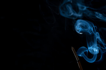 Incense stick with abstract of smoke on black background