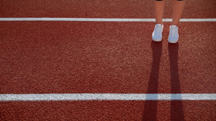 Shadow from legs on red court. Close up of female runner in black legging and w sneakers spending morning time at local stadium. Female sporty model. Concept of sport activity.