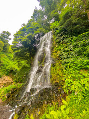 Beautiful waterfall surrounded by a green landscape in Sao Miguel, Azores.