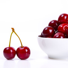 Cherry berries in a white cup on a white background. Isolated. Ripe cherries. Red delicious cherry.