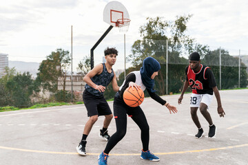 Diverse people playing basketball on court