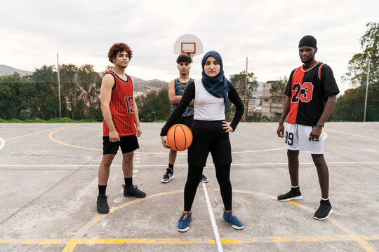 Diverse streetball players standing together on basketball court