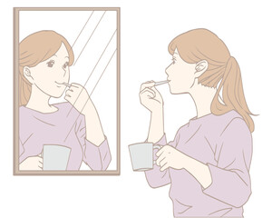 鏡を見て歯みがきをする女性（パステルカラー）