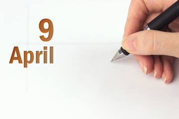 April 9th. Day 9 of month, Calendar date. The hand holds a black pen and writes the calendar date....