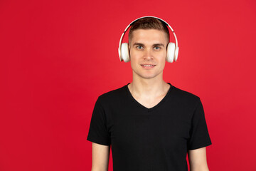 Caucasian man's portrait isolated over red studio background with copyspace for ad. Concept of human emotions