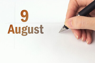 August 9th. Day 9 of month, Calendar date. The hand holds a black pen and writes the calendar date....