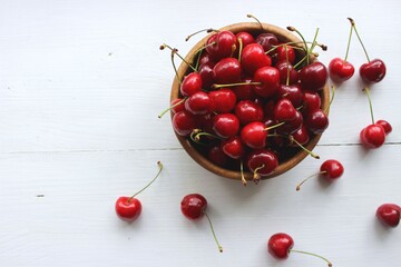 Fototapeta na wymiar cherries in a wooden bowl on a white background