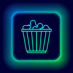 Glowing neon line Popcorn in cardboard box icon isolated on black background. Popcorn bucket box. Colorful outline concept. Vector