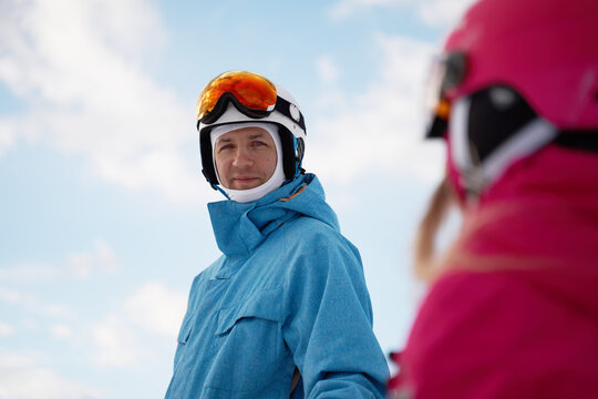 Parent and kid skiing on snowy hill slope