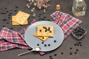 Blueberries and biscuits on gray plate.