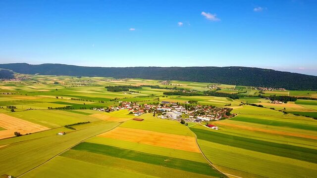 Aerial shot of the gorgeous farmlands and houses in Les Hauts-Geneveys of western Switzerland