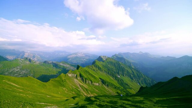 Time-lapse of the clouds moving over the green Fluebrig, mountain view
