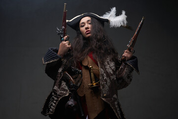 Caribbean female corsair with guns against dark background