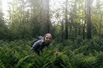 girl in a foggy forest among ferns is passionate about nature