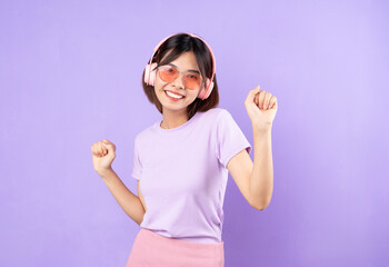 portrait of young asian girl listening to music with headphones, isolated on hip color background