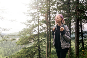 teenage girl doing backpacking in a mountain forest