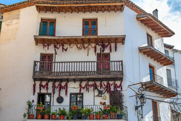 Facade of traditional rural house decorated with red peppers or paprika hanging in Cazorla, Andalusia, Spain