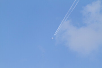 Airplane in blue sky with white clouds
