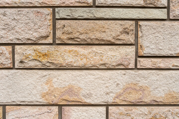 Wall built with decorative rustic rectangular stones. Texture wallpaper.