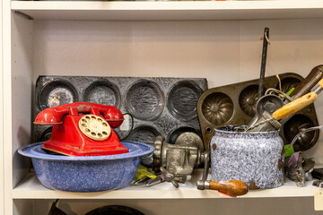 Collection and Antiques of Kitchen Stuff on a Shelf with a red phone