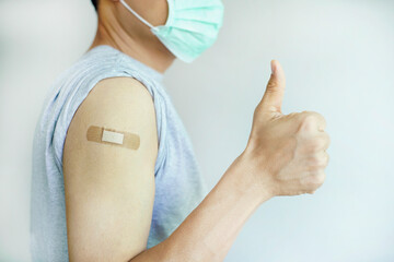 A man showing his arm with wound plaster and show thumb up feeling good and be strong                                                                