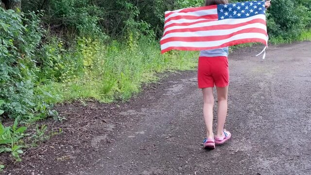 USA flag is in the hands of a child fan in a red wig. 4 of Jule.