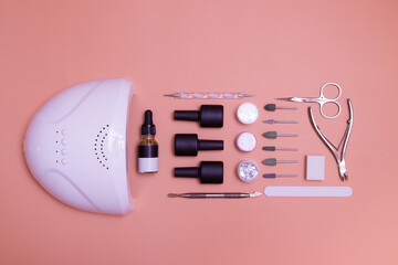 Top view of tools and materials for modern gel manicure and nail extension. Knolling on a color...