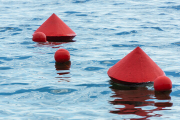Red buoys on the water surface. Buoys warning of danger at sea.