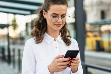 Business woman texting messages while walking. Woman with phone in subway train station. Transport app concept. Travel app.