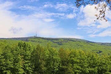 Fototapeta na wymiar Beautiful scenery of the mountains and view to the transmitter with green forests and blue sky above at White Carpathians, Czech republic