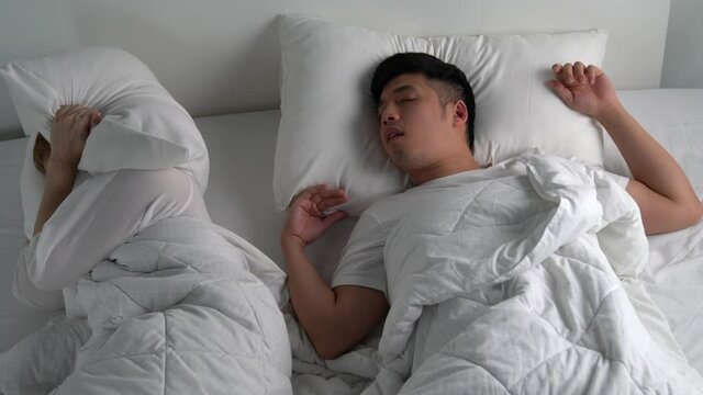 Young Asian man snoring While sleeping in bed.